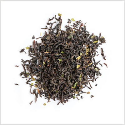 Pile of loose leaf black tea showing ingredient detail including light green lemon myrtle.