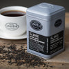 Silver tin of Barrel Aged Black tea on wooden table.