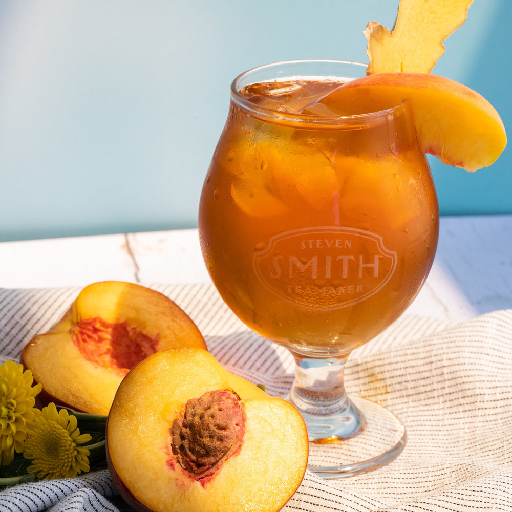 Glass of Ginger Peach iced tea with a slice of peach and ginger.